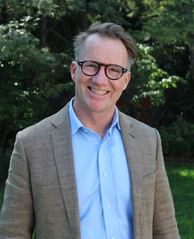 man in gray suit jacket wearing eyeglasses